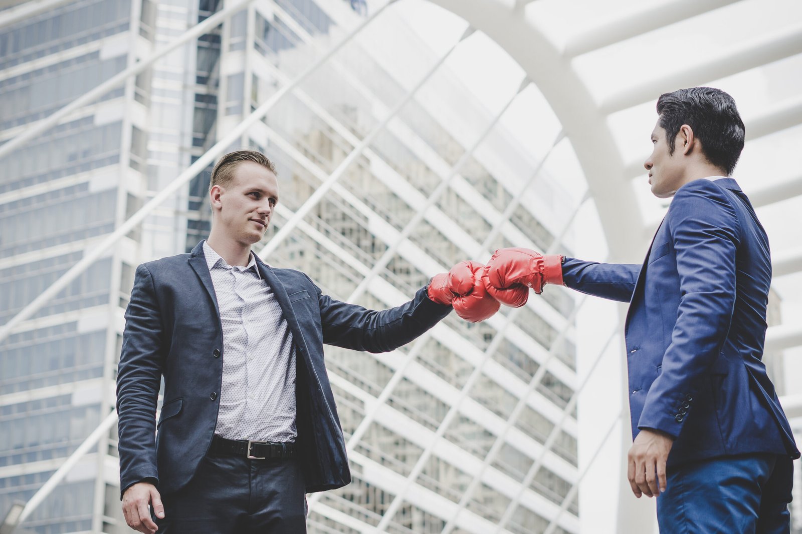 businessman with red boxing gloves ready fight his coworker scaled