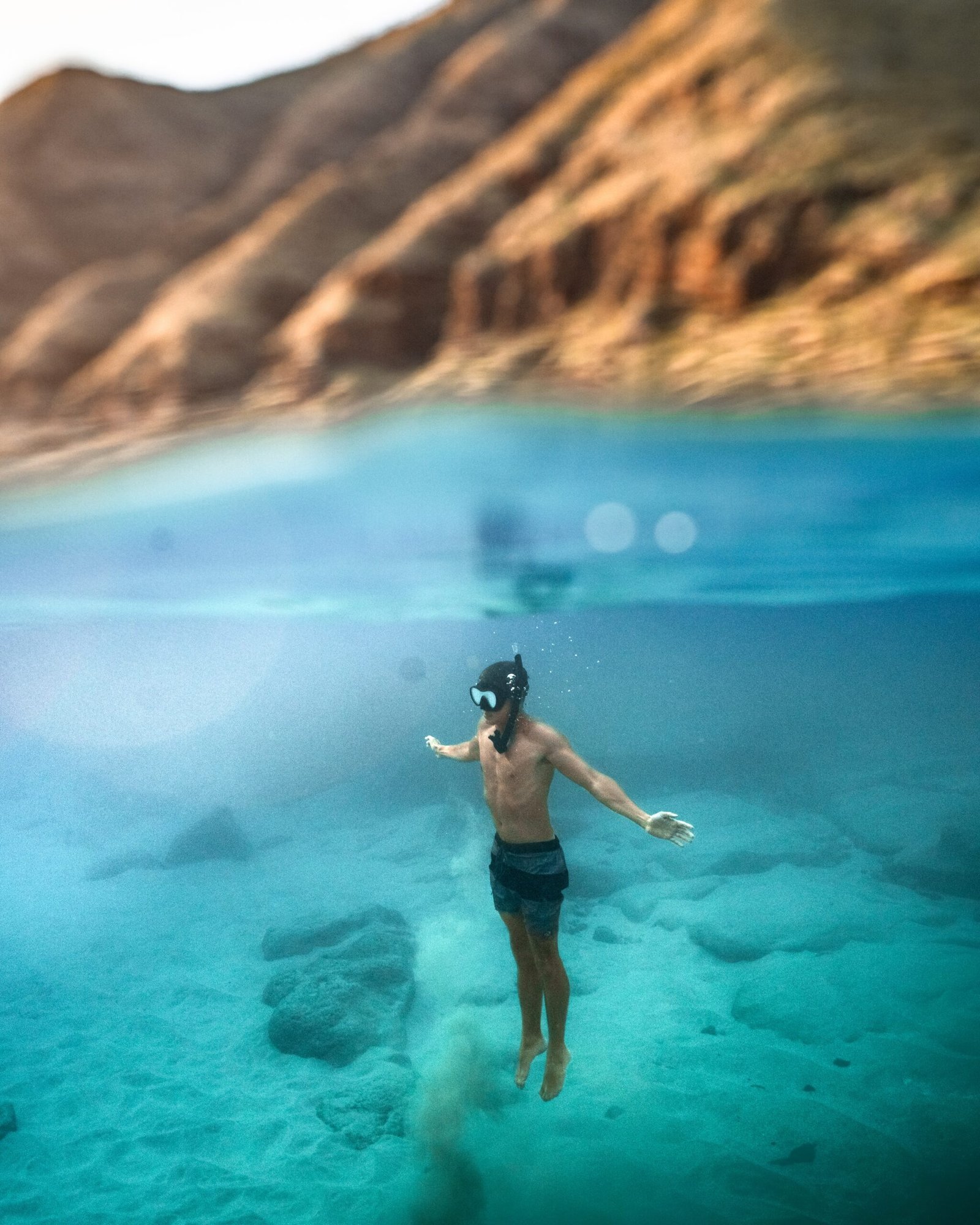 vertical shot male diving turquoise sea scaled